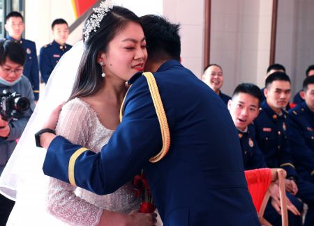 (miniature) Le pompier Yuan Yang embrasse son épouse Xu Lu lors d'une cérémonie de mariage de groupe à Shanghai