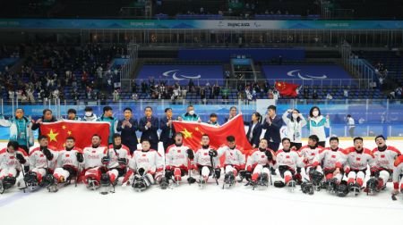 (miniature) Les athlètes chinois posent pour une photo avec les membres de l'équipe après le match pour la médaille de bronze de para-hockey sur glace entre la Chine et la République de Corée