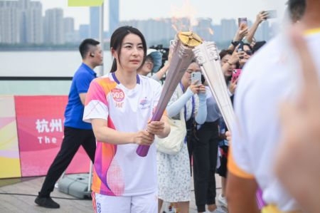 (miniature) La porteuse de la torche Guo Jingjing transmet la flamme lors du relais de la flamme des Jeux asiatiques de Hangzhou
