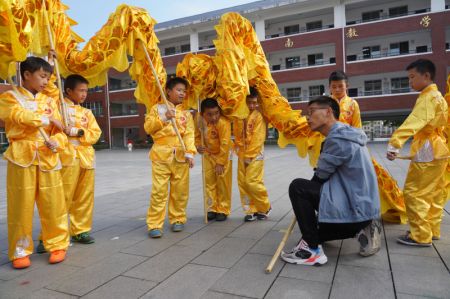 (miniature) L'entraîneur Yan Wenlong enseigne à ses élèves la danse traditionnelle du dragon à l'école primaire N° 2 de Jing'an