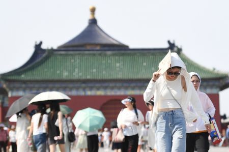 (miniature) Une touriste se sert d'un sac en papier pour se protéger du soleil au parc du Temple du ciel