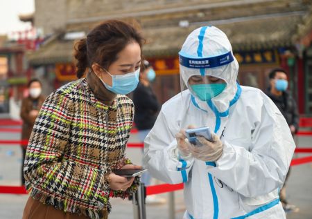 (miniature) Une membre du personnel médical aide une habitante à enregistrer ses informations personnelles pour un test d'acide nucléique à Hohhot