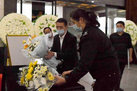 (miniature) Des membres du personnel placent des bouquets offerts par des habitants locaux dans la salle aménagée en hommage à Yuan Longping