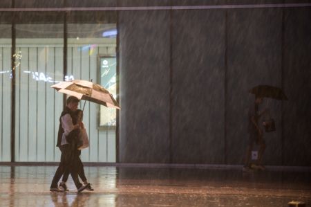 (miniature) Des gens marchent sous la pluie dans l'arrondissement de Daxing