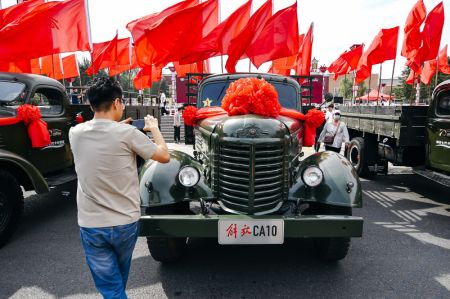 (miniature) Un homme prend des photos de camions Jiefang de différentes générations lors de célébrations à l'approche du 70e anniversaire du constructeur FAW Group