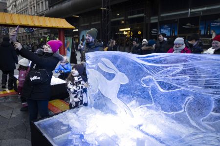 (miniature) Des visiteurs prennent des selfies devant une sculpture de glace sur le thème du lapin lors d'une exposition de sculptures de glace organisée pour le Nouvel An chinois à Helsinki