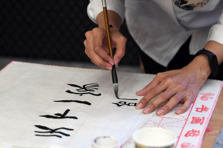 (miniature) Une participante écrit des caractères chinois avec un pinceau lors de la 22e édition du concours de maîtrise du mandarin Pont vers le chinois pour les étudiants iraniens à Téhéran