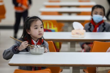 (miniature) Une écolière mange à la cantine dans une école primaire de Guiyang