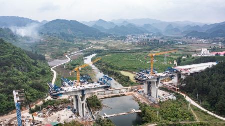 (miniature) Photo aérienne prise par un drone le 17 avril 2024 montrant le pont de la rivière Bailong sur le tracé de l'autoroute Guiyang-Pingtang en construction dans la province chinoise du Guizhou (sud-ouest)
