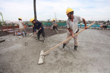 (miniature) Des ouvriers bravent la chaleur en travaillant sur un chantier dans le bourg de Wantou