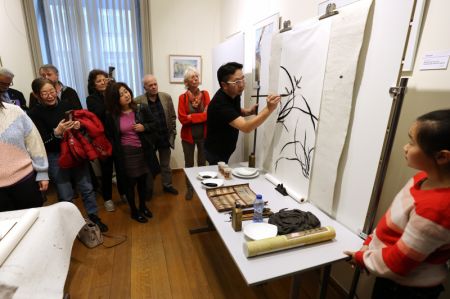 (miniature) Des visiteurs regardent un artiste chinois faire la démonstration de la manoeuvre d'un pinceau lors du salon de la culture Lanting qui s'est tenu au Centre culturel chinois à Bruxelles