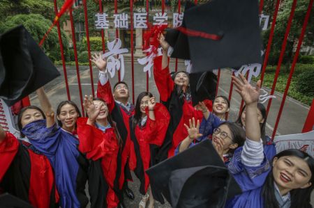 (miniature) Des étudiants célèbrent l'obtention de leur diplôme après une cérémonie de remise des diplômes au Centre des sciences de la santé de l'Université de Pékin