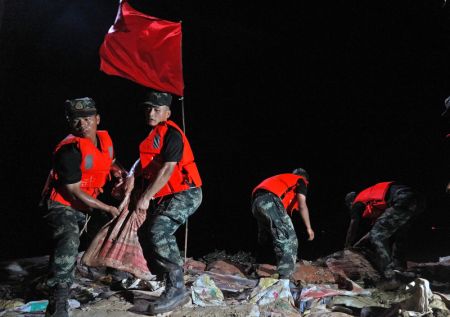(miniature) Des policiers armés transportent des sacs de sable sur une digue à Poyang