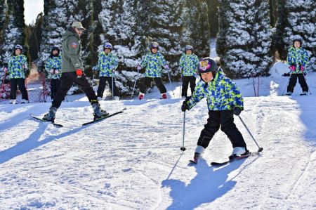 (miniature) Un moniteur apprend à un enfant à faire du ski dans une station de sports d'hiver à Qingzhou
