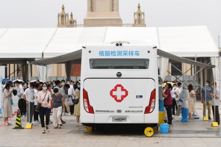 (miniature) Des professionnels de santé effectuent des prélèvements de gorge sur des habitants dans un véhicule de dépistage mobile récemment mis en service dans l'arrondissement de Xicheng
