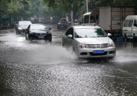 (miniature) Des véhicules circulent dans une rue inondée