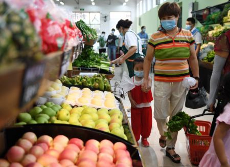 (miniature) Des consommateurs achètent des légumes dans une épicerie installée récemment près du marché de gros de Xinfadi à Beijing