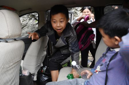 (miniature) Des élèves montent à bord d'un véhicule pour aller à l'école après avoir traversé une route endommagée dans le bourg de Luotang de la ville de Longnan