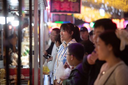 (miniature) Des touristes font la queue pour acheter à manger dans un marché de nuit à Yichun