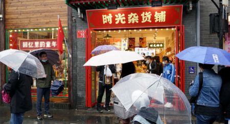 (miniature) Des gens passent devant un magasin dans la ruelle de Nanluoguxiang durant les congés d'une semaine de la fête nationale