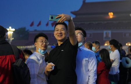 (miniature) Des gens prennent un selfie avant la cérémonie de lever du drapeau national sur la place Tian'anmen