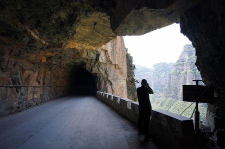 (miniature) Un touriste prend des photos sur une route creusée dans une falaise dans le district de Pingshun