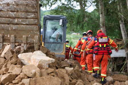 (miniature) Des sauveteurs vont porter secours à un villageois pris au piège des décombres dans le bourg de Kaiyuan à Shulan