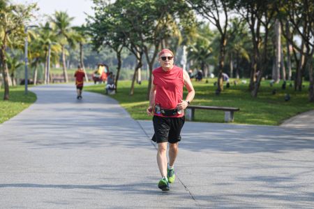 (miniature) Un homme fait du jogging au parc Evergreen de Haikou