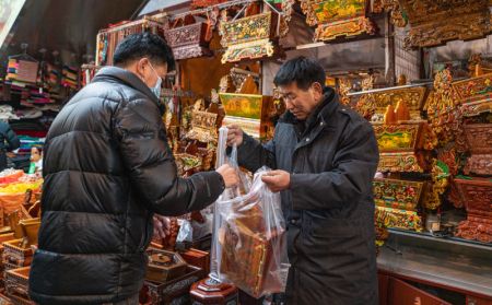 (miniature) Un homme achète des boîtes de chema sur un marché local pour le prochain Nouvel An chinois à Lhassa