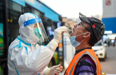 (miniature) Un membre du personnel médical prélève un échantillon de gorge sur un habitant pour un test d'acide nucléique à Hohhot