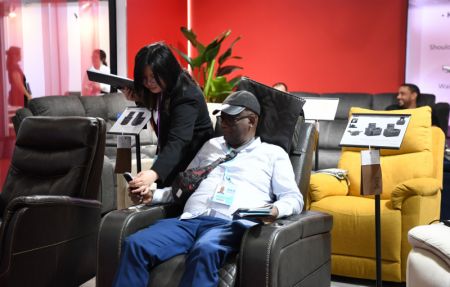(miniature) Un visiteur essaie un fauteuil de massage lors de la deuxième phase de la 133e Foire des importations et des exportations de Chine