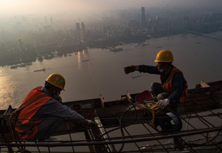 (miniature) Des ouvriers travaillent à une hauteur d'environ 500 mètres sur le chantier d'un gratte-ciel à Wuhan