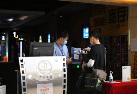 (miniature) Un homme scanne un code QR pour s'enregistrer dans un cinéma de Tianjin