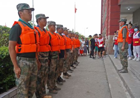 (miniature) Des vétérans bénévoles rassemblés dans un abri temporaire pour les évacués dans le district de Poyang de la province chinoise du Jiangxi (est)