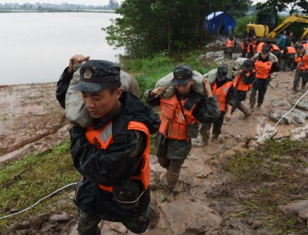 (miniature) Des policiers armés portent des sacs de sable sur la digue de la rivière Shiba
