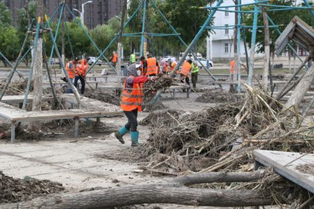 (miniature) Des travailleurs nettoient une route après les inondations à Shangzhi
