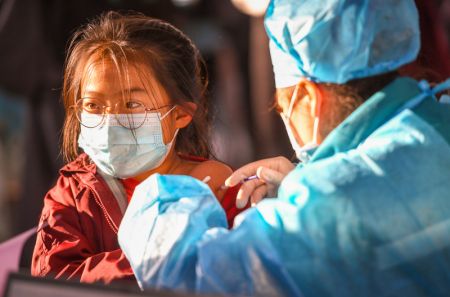 (miniature) Une fille reçoit une dose de vaccin de COVID-19 dans une école à Hohhot