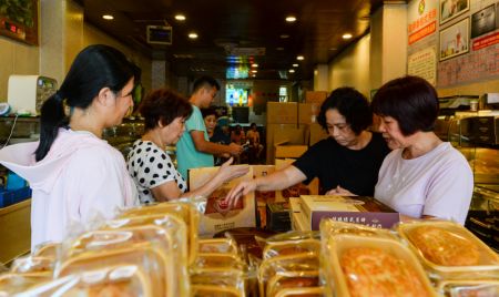(miniature) Des consommateurs choisissent des gâteaux de lune dans un magasin de gâteaux de lune à la mode de Hainan