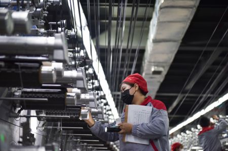 (miniature) Une employée vérifie le fonctionnement d'une chaîne de production dans la base de production de la société Zhongfu Shenying Carbon Fiber Co