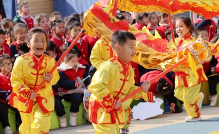(miniature) Des enfants exécutent la danse du dragon pour célébrer le Nouvel An dans une école maternelle à Huzhou
