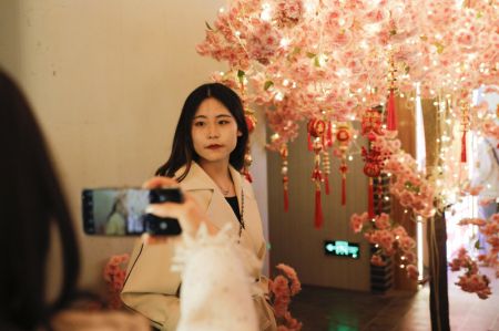 (miniature) Une visiteuse pose pour des photos dans un marché de nuit à Lanzhou