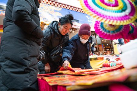 (miniature) Des gens achètent des couplets de la fête du Printemps sur un marché local pour le prochain Nouvel An chinois à Lhassa