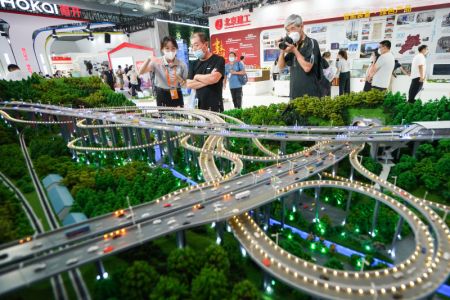 (miniature) Des visiteurs regardent le modèle réduit de l'échangeur de Qianchun dans la zone d'exposition des services de conseil en ingénierie et de construction lors du Salon international du commerce des services de Chine (CIFTIS) 2021