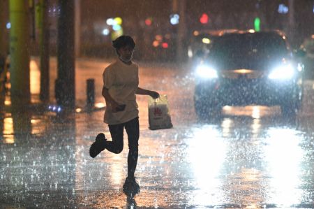 (miniature) Une femme court sous la pluie dans l'arrondissement de Chaoyang