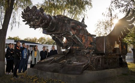 (miniature) Des touristes contemplent une sculpture réalisée avec des équipements miniers dans le parc industriel culturel de Zhongneng