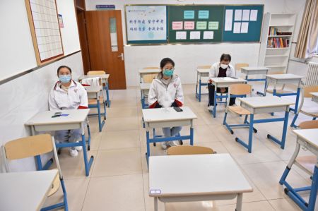 (miniature) Des employés font la répétition du retour des élèves dans une salle de classe dans le département de collège de l'école secondaire Chenjinglun à Beijing