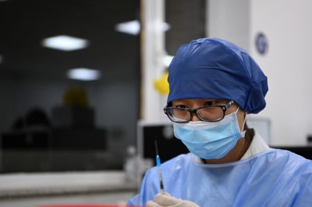 (miniature) Un membre du personnel médical prépare une dose de vaccin contre la COVID-19 sur un site de vaccination de l'arrondissement de Nankai à Tianjin