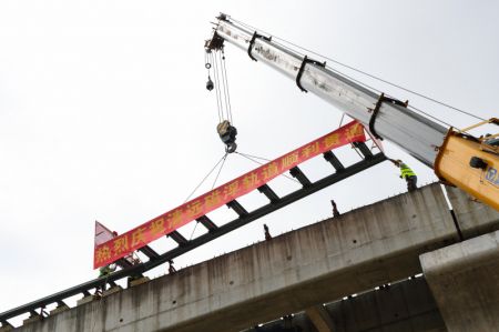 (miniature) Des ouvriers posent le dernier rail de 10 mètres de long sur le chantier d'une ligne maglev à moyenne et basse vitesse dans la ville de Qingyuan