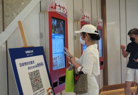 (miniature) Une spectatrice prend son ticket dans un cinéma UME à Shanghai
