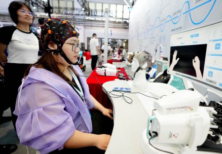 (miniature) Un employé fait une démonstration d'une interface cerveau-ordinateur pour la rééducation post-AVC lors de la Conférence mondiale sur la robotique 2023 qui se tient à Beijing